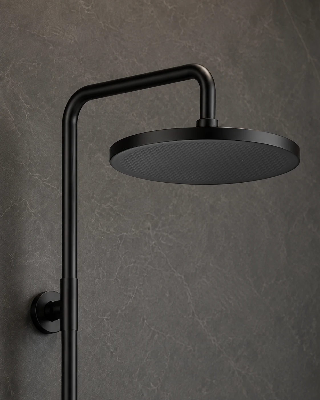 Close-up of the matte black Dana rain head on dark stone