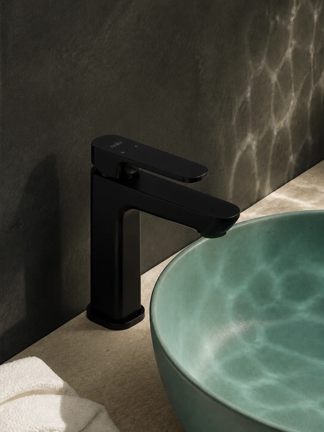 Rear angle of the matte black Tala mixer with an aqua glazed bowl and charcoal wall