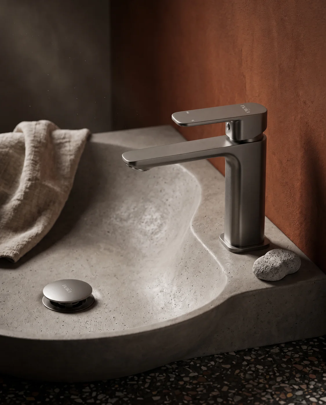 Gun grey Tala mixer on a sculpted concrete basin with rust walls