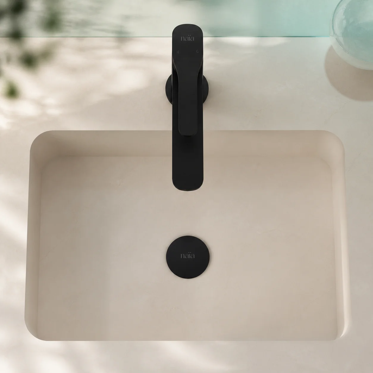 Top view of the Tala mixer and its matching matte black pop-up waste in a cream basin